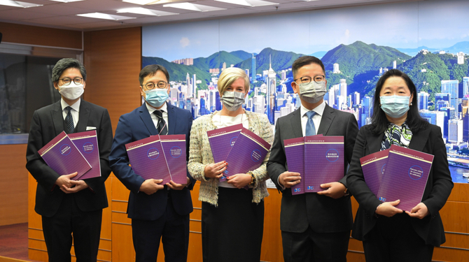 Interior line up-of report's authors holding copies of the report