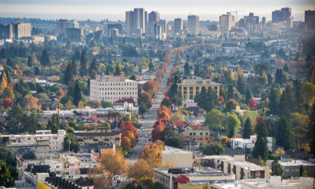 Aerial view of north Oakland on a sunny autumn evening; downtown Oakland in the background; buildings in UC Berkeley in the foreground; San Francisco bay, California