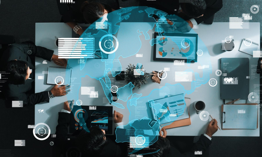 Executives sitting round a desk with lots of technology